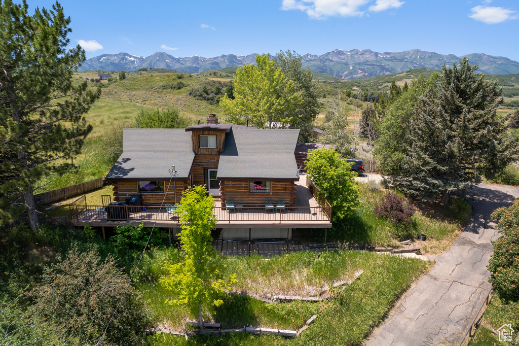 Aerial view of property and surrounding area featuring a mountainous background