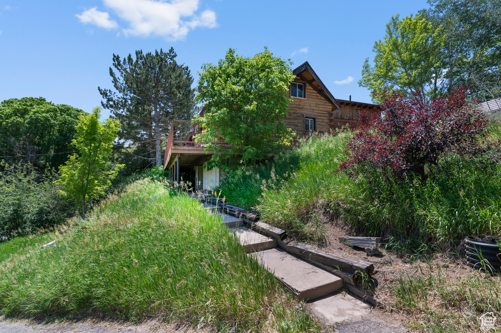 View of front of house with log exterior and a deck