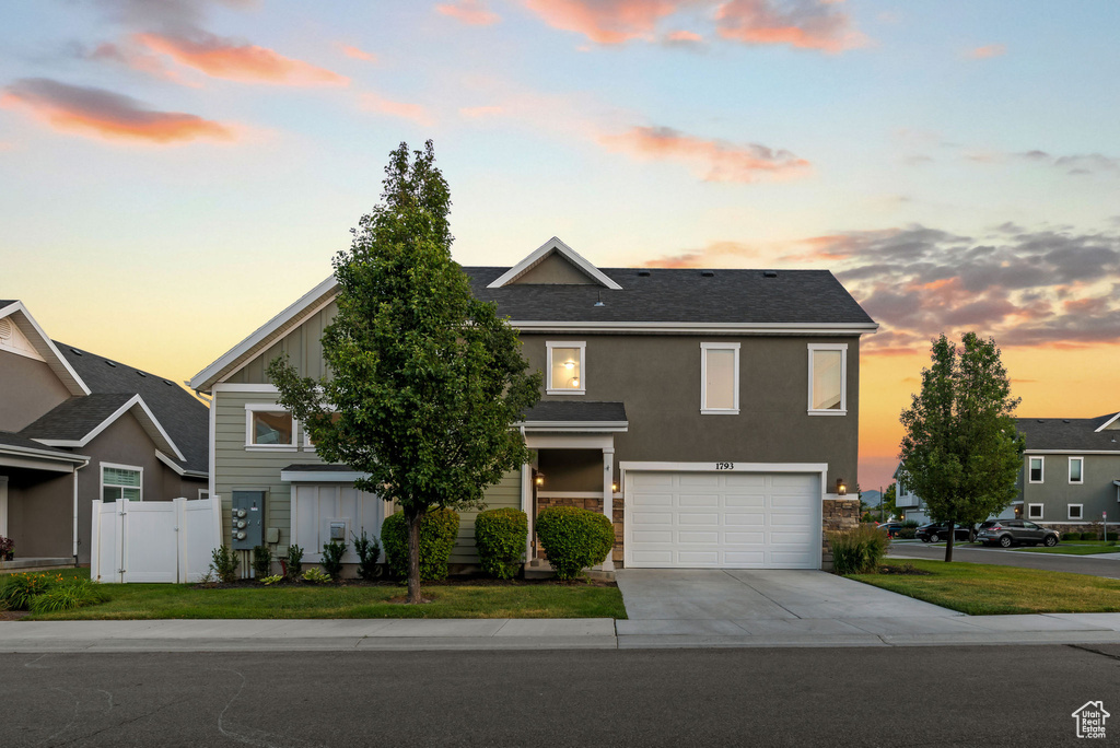View of front facade with driveway, a garage, and board and batten siding