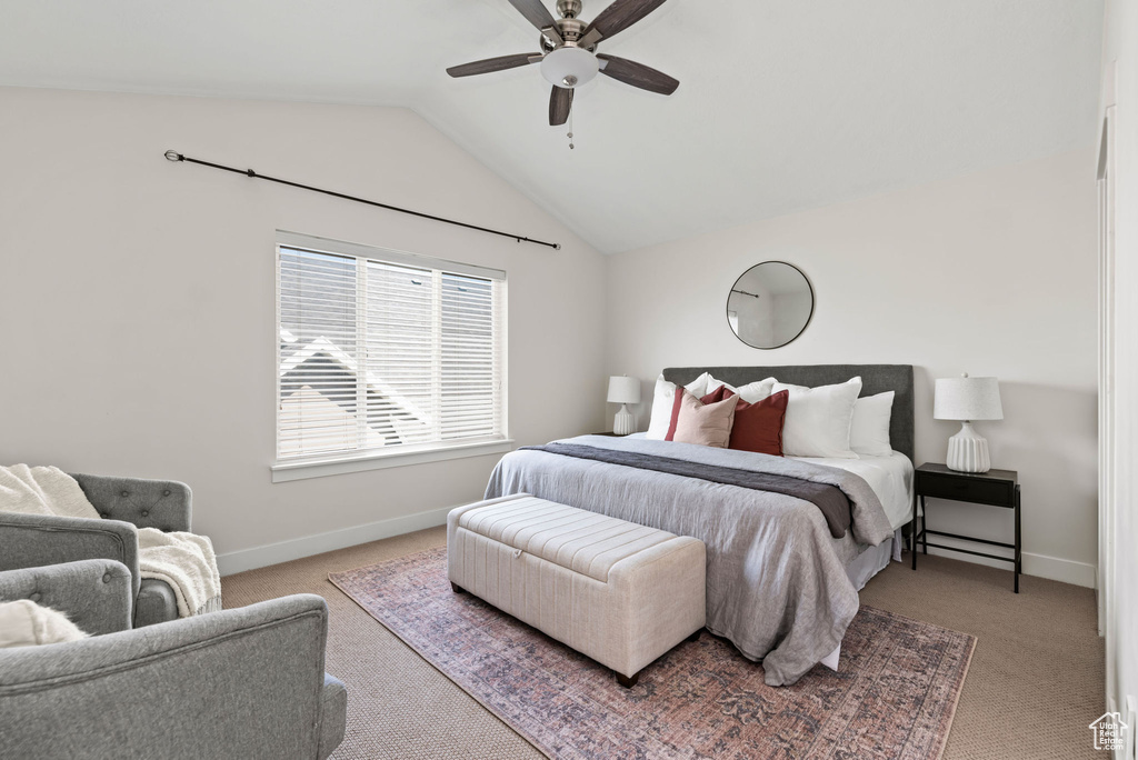 Carpeted bedroom with vaulted ceiling and a ceiling fan