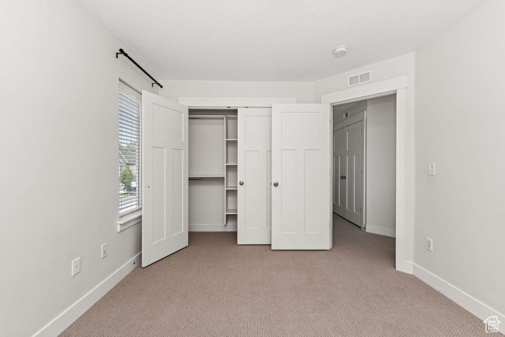 Unfurnished bedroom with carpet floors and a closet