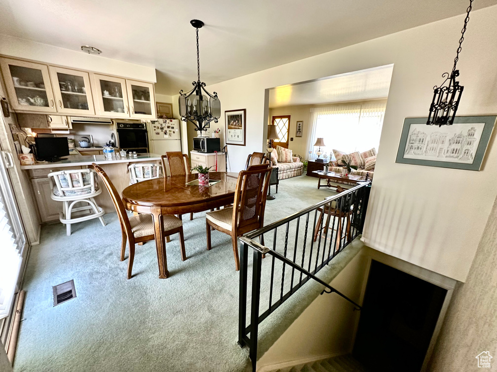 Dining room featuring light colored carpet and a chandelier