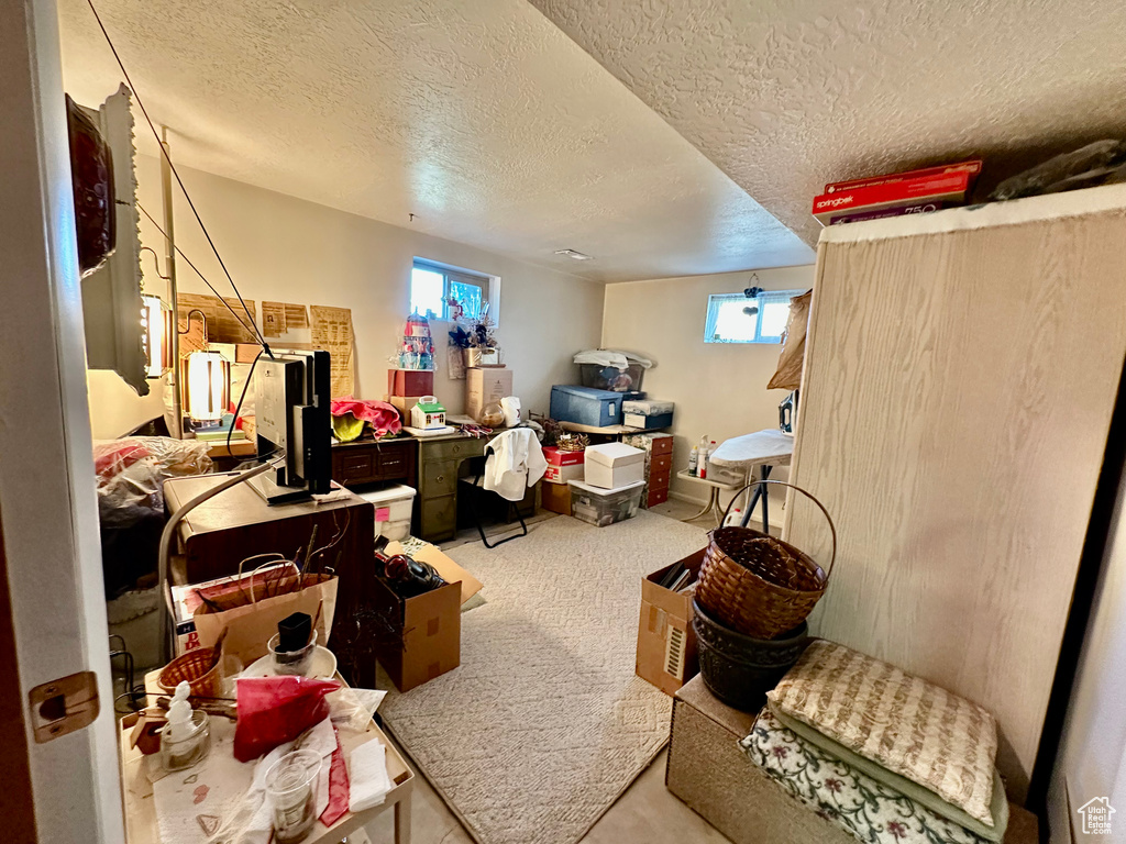Basement with a textured ceiling and carpet