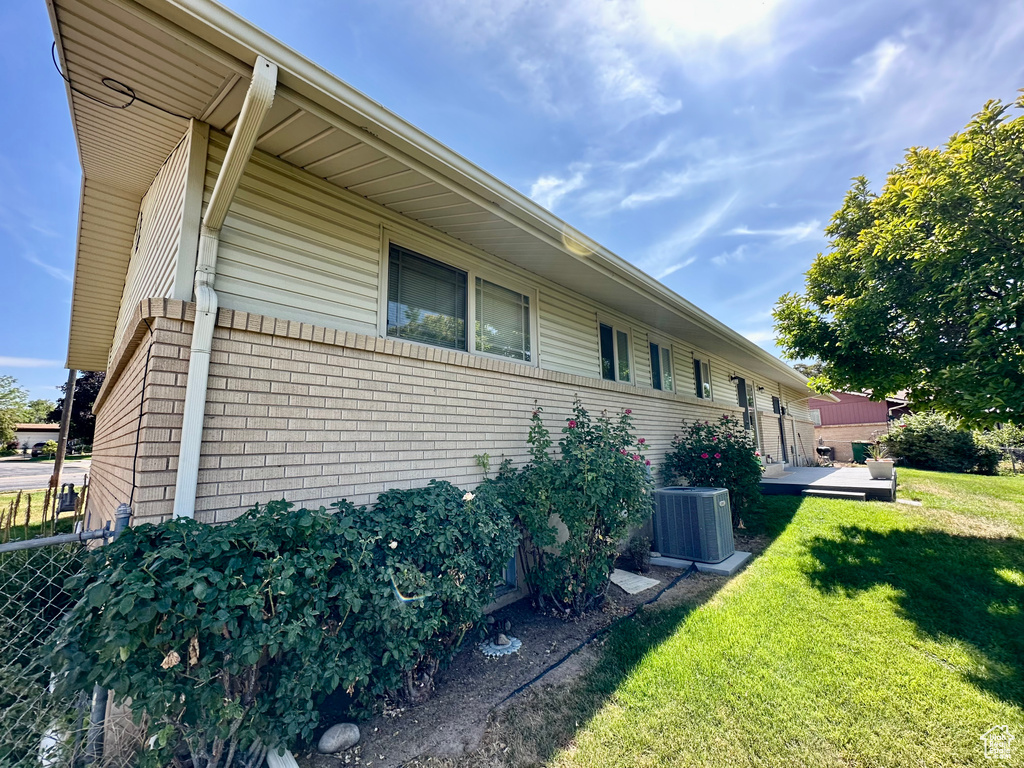 View of home\\\'s exterior with a cooling unit and brick siding