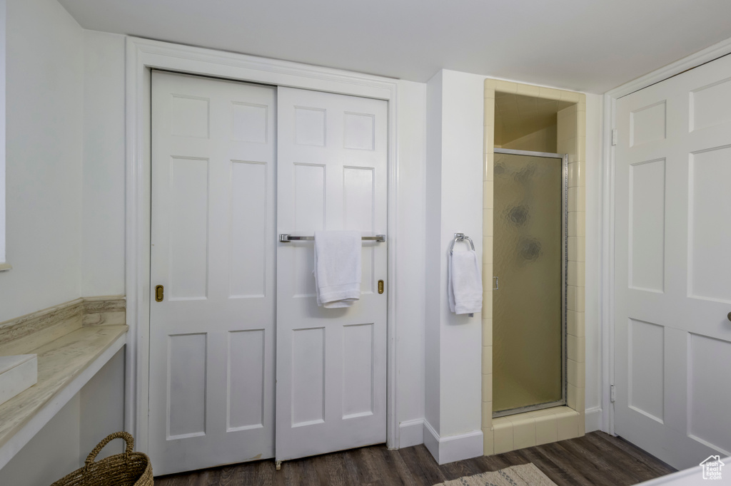 Full bath with a stall shower and wood finished floors