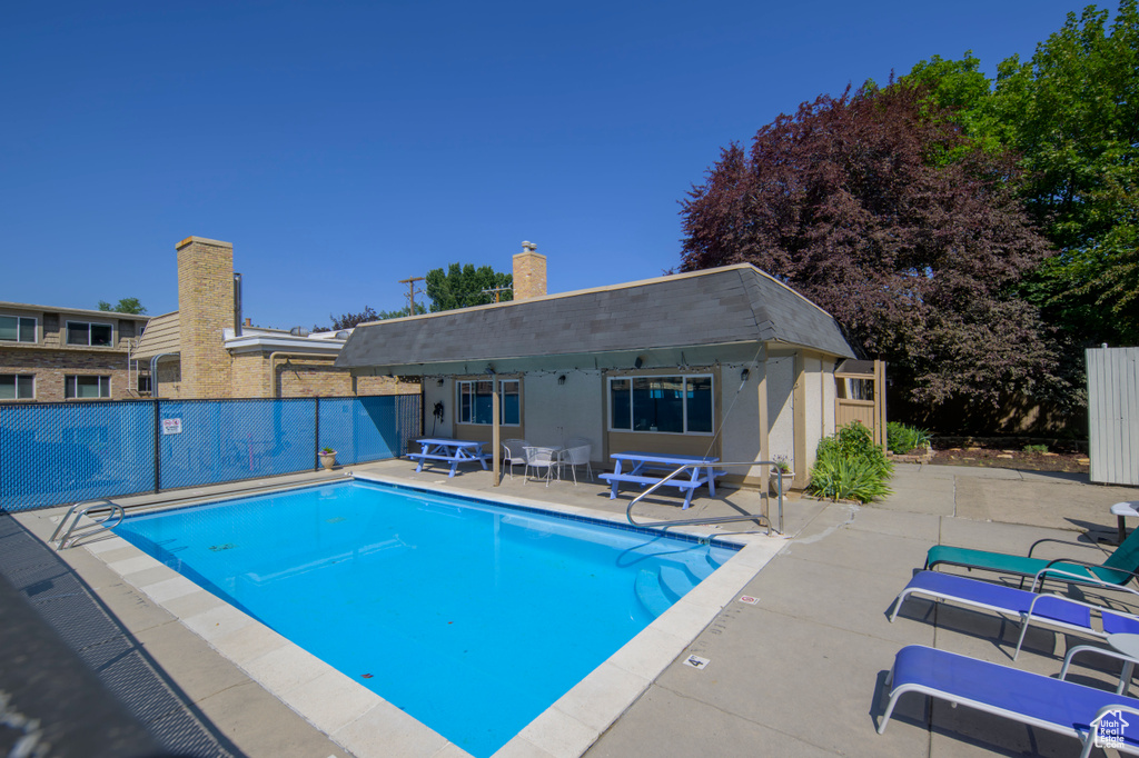 Community pool featuring a patio, a storage structure, and an outbuilding