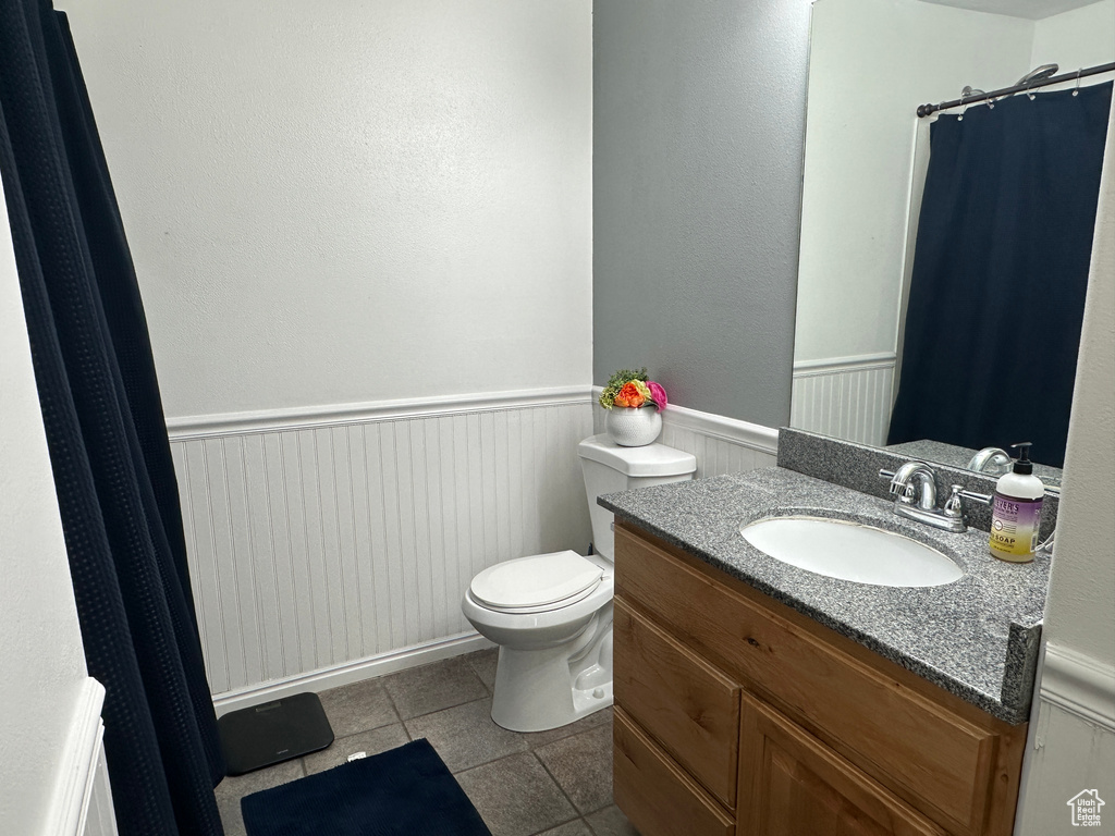 Full bathroom with wainscoting, vanity, tile patterned flooring, and a shower with shower curtain