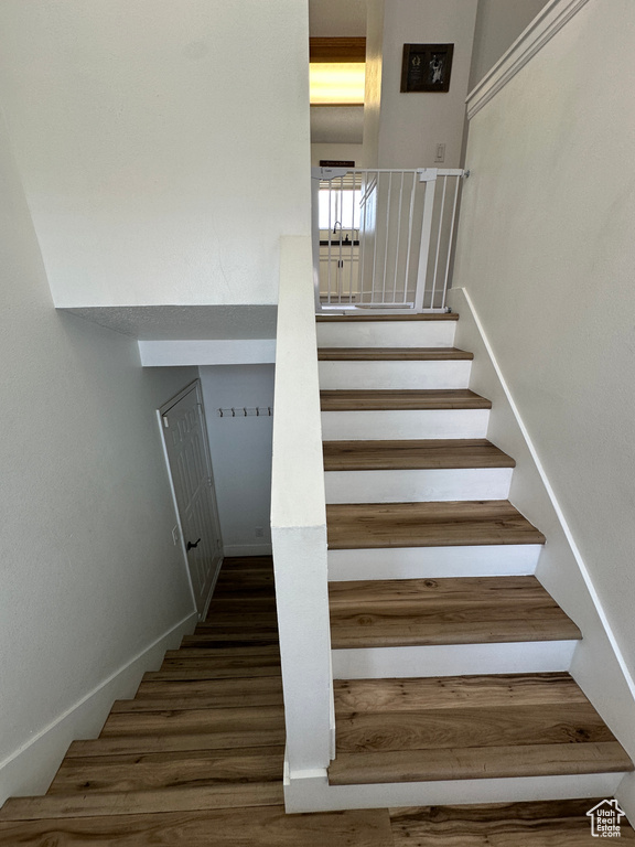 Stairs featuring wood finished floors and baseboards