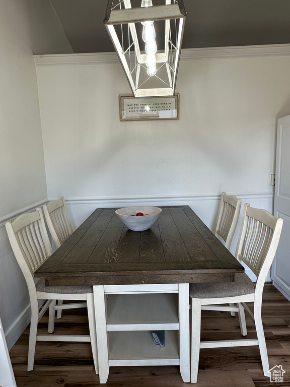 Dining area featuring a chandelier, ornamental molding, and wood finished floors