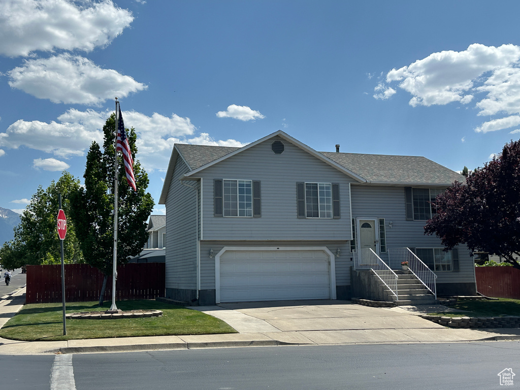 Raised ranch featuring a garage and driveway