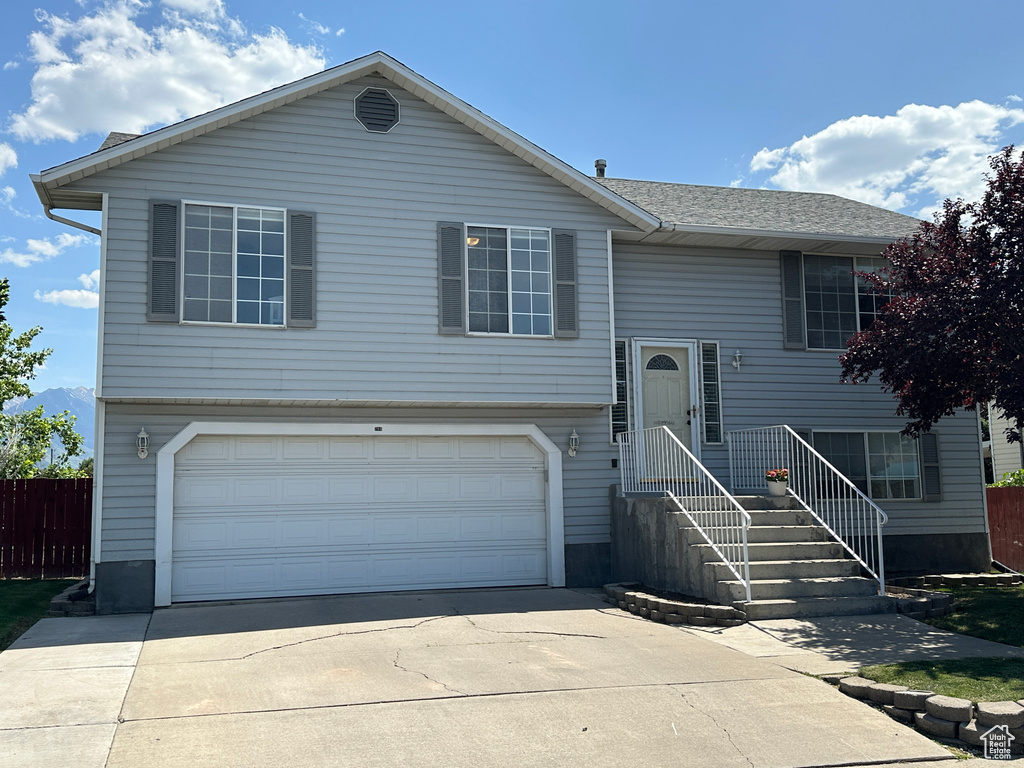 Split foyer home with an attached garage and concrete driveway