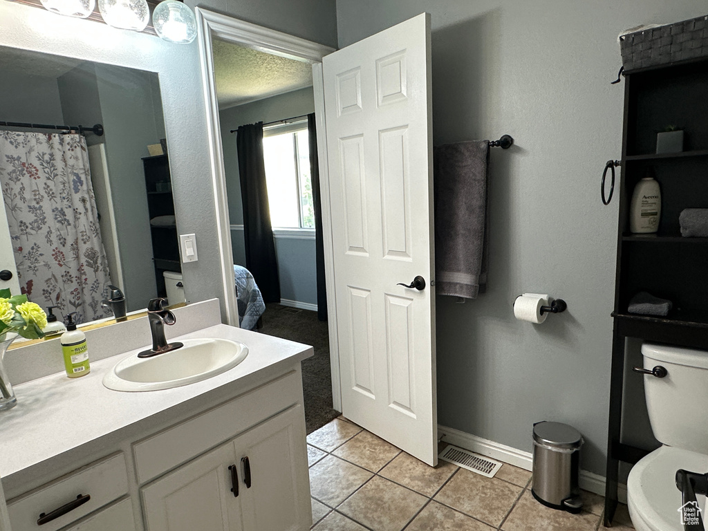 Ensuite bathroom with vanity and tile patterned flooring