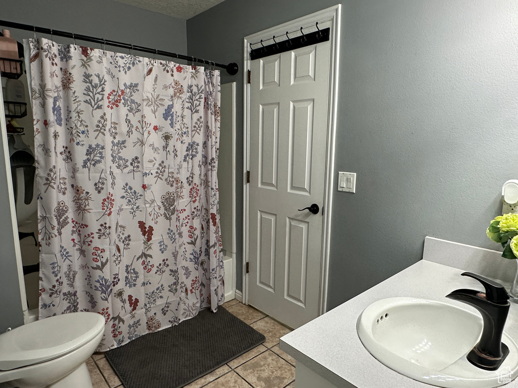 Full bath featuring vanity, shower / tub combo, and tile patterned floors