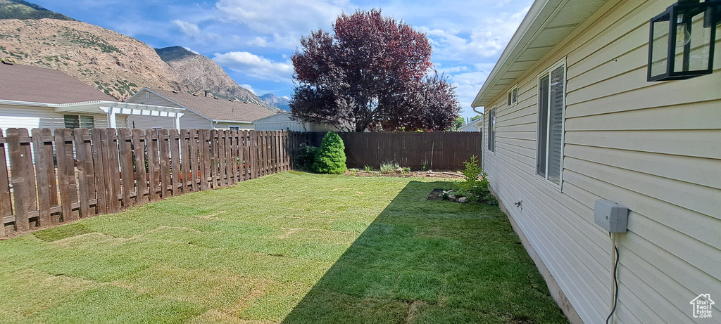 Fenced backyard featuring a mountain view