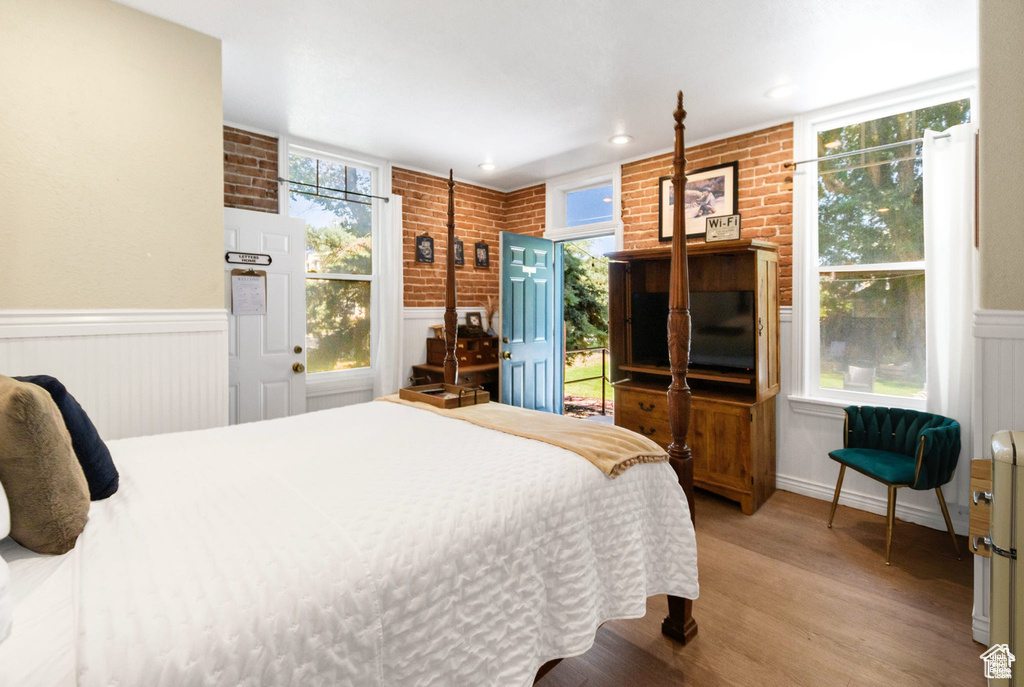 Bedroom featuring light wood-type flooring, a wainscoted wall, and recessed lighting