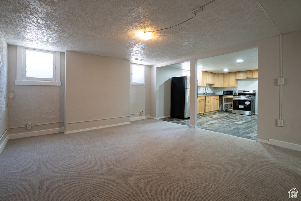 Unfurnished living room with a textured ceiling and light carpet