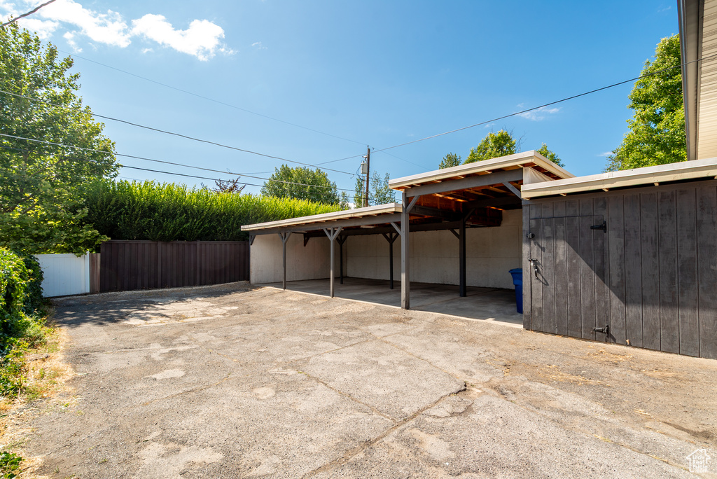 Garage with concrete driveway and a carport
