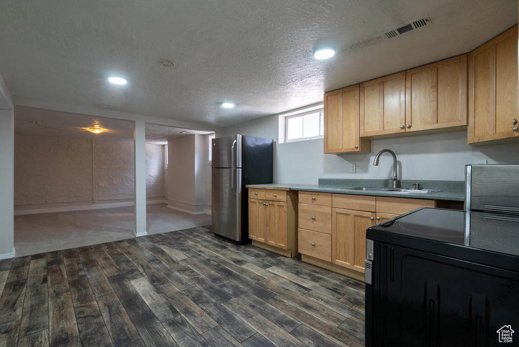 Kitchen with freestanding refrigerator, dark wood-style flooring, a textured ceiling, recessed lighting, and light countertops