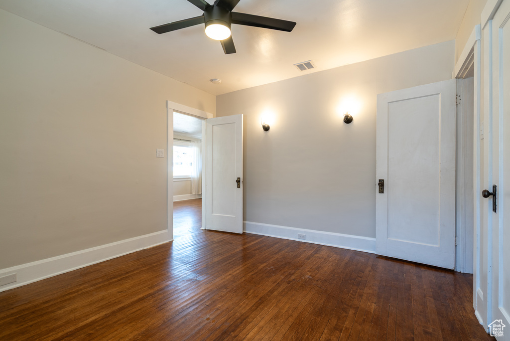 Spare room with dark wood finished floors and ceiling fan