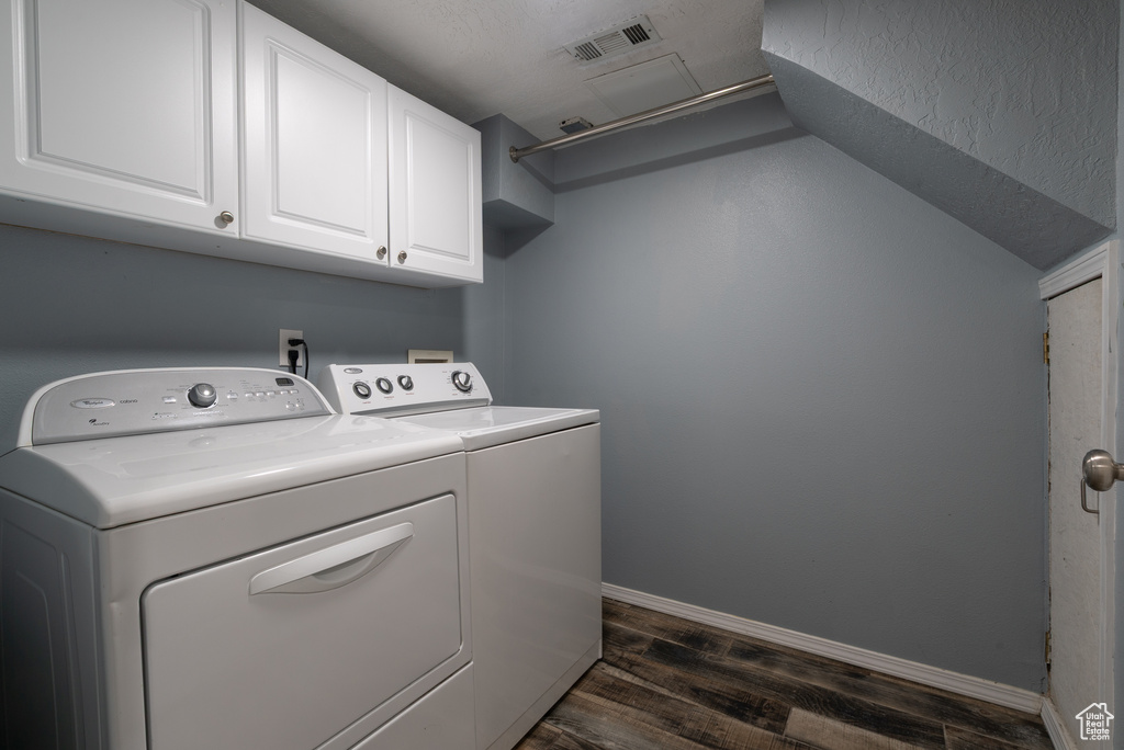 Laundry area featuring cabinet space, washer and clothes dryer, and dark wood-style floors