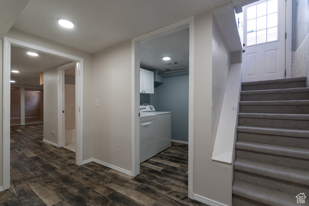 Stairs with washer and dryer, wood finished floors, and recessed lighting