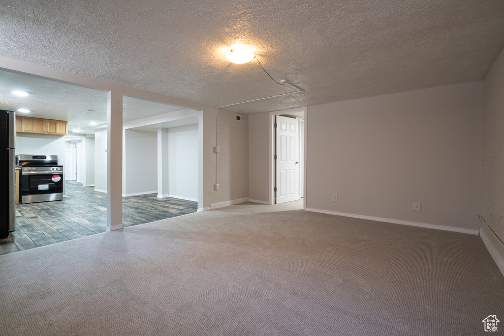 Unfurnished living room featuring a textured ceiling and carpet