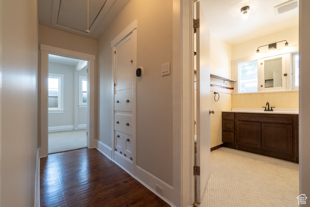 Hall featuring attic access and wood finished floors
