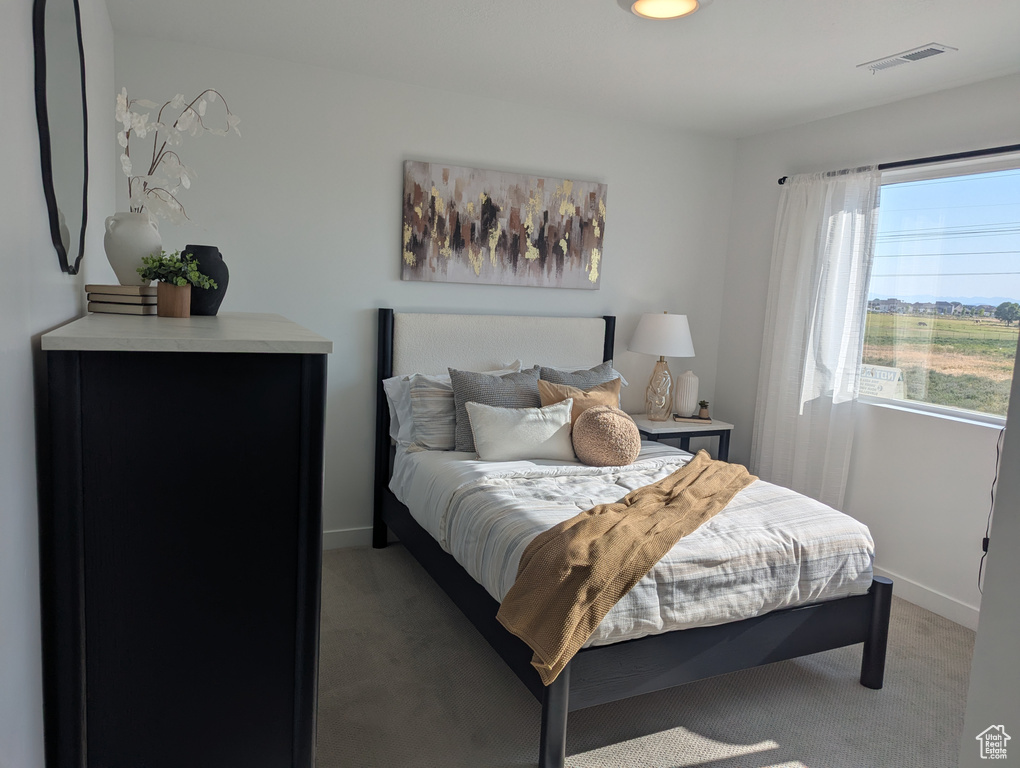 Bedroom featuring light carpet and baseboards