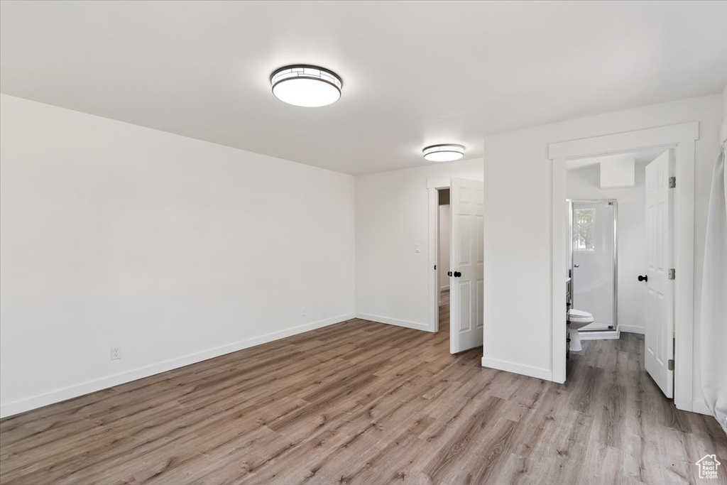 Unfurnished bedroom with light wood-style floors and baseboards