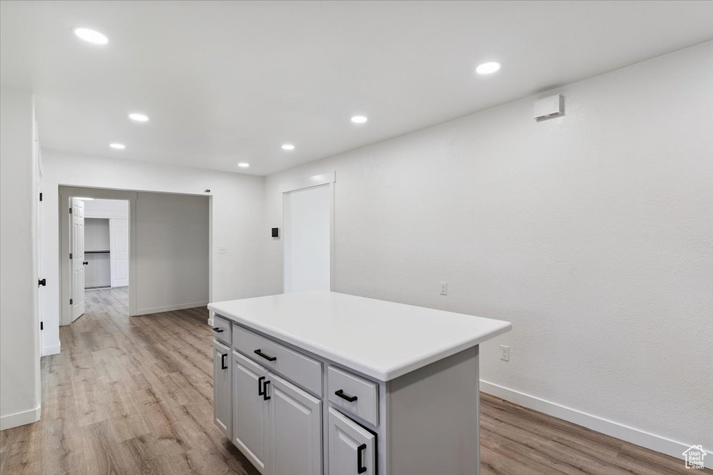 Kitchen featuring light wood-style flooring, a center island, recessed lighting, and light countertops