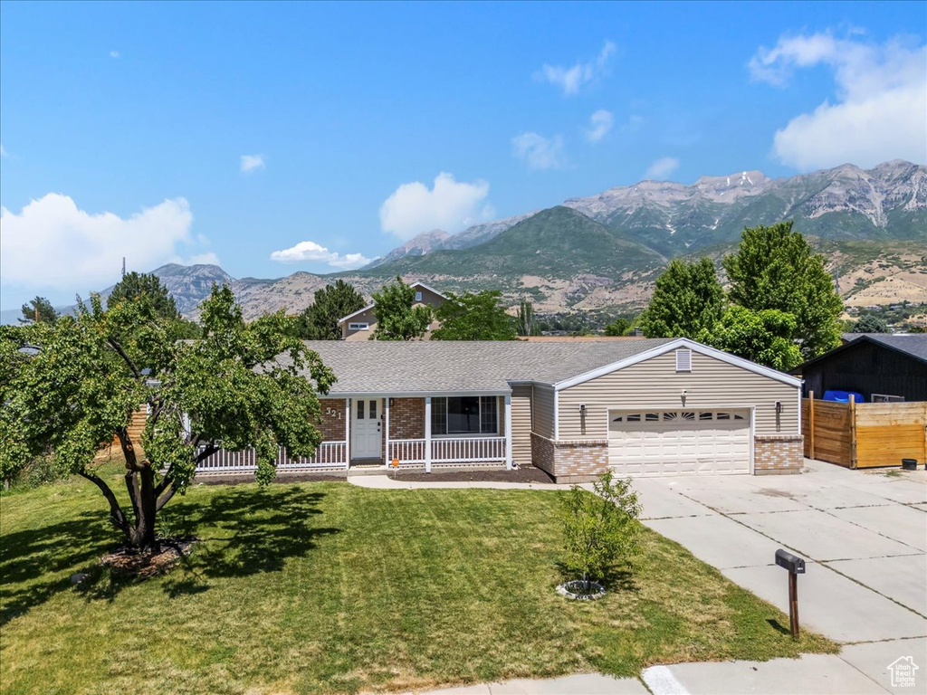 Ranch-style home with brick siding, driveway, a mountain view, and covered porch