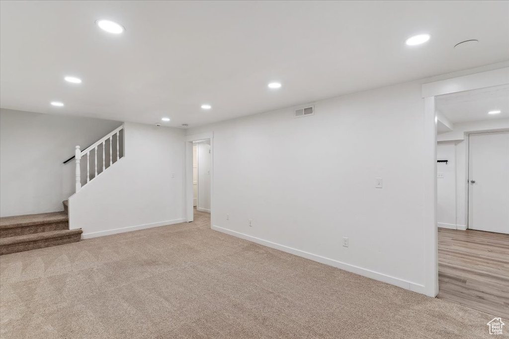 Finished below grade area featuring recessed lighting, light carpet, and stairs
