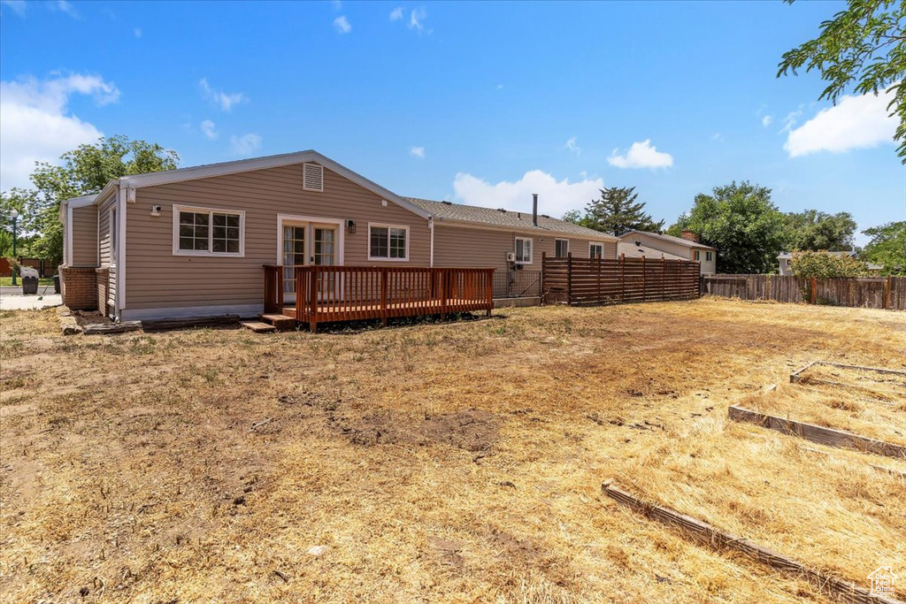 Back of house featuring a wooden deck and french doors