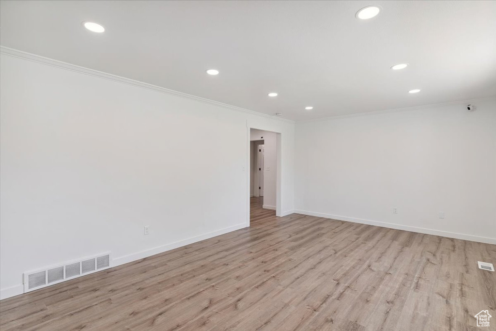 Empty room with ornamental molding, recessed lighting, and light wood-style flooring