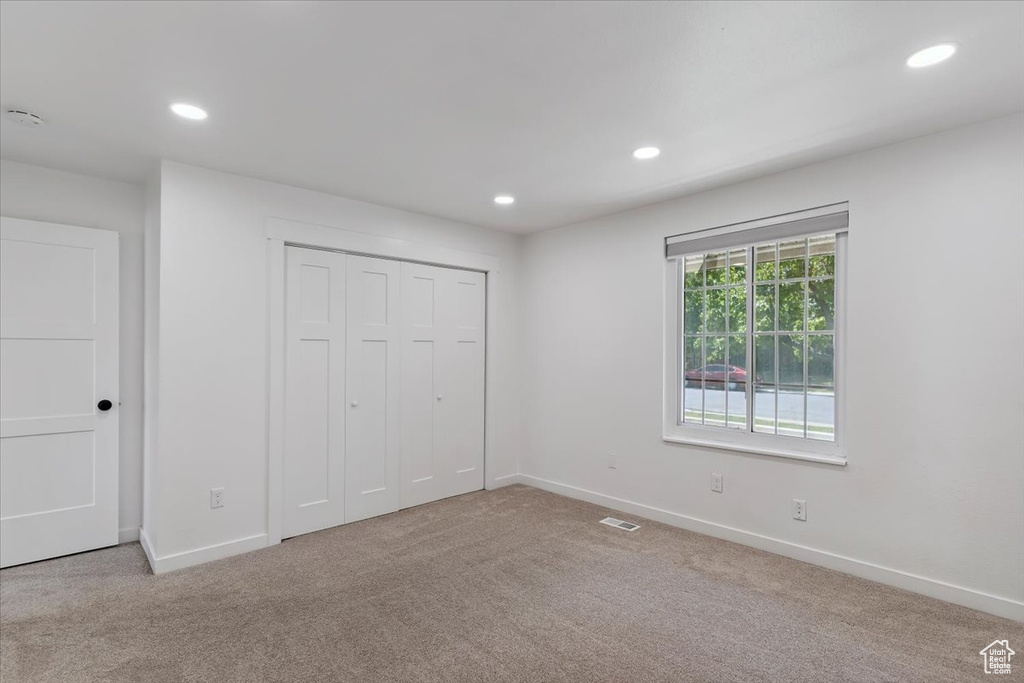 Unfurnished bedroom featuring carpet flooring, recessed lighting, and a closet