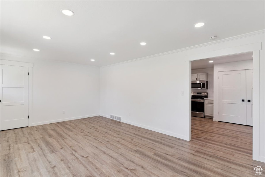 Spare room featuring recessed lighting, crown molding, light wood finished floors, and a smoke detector