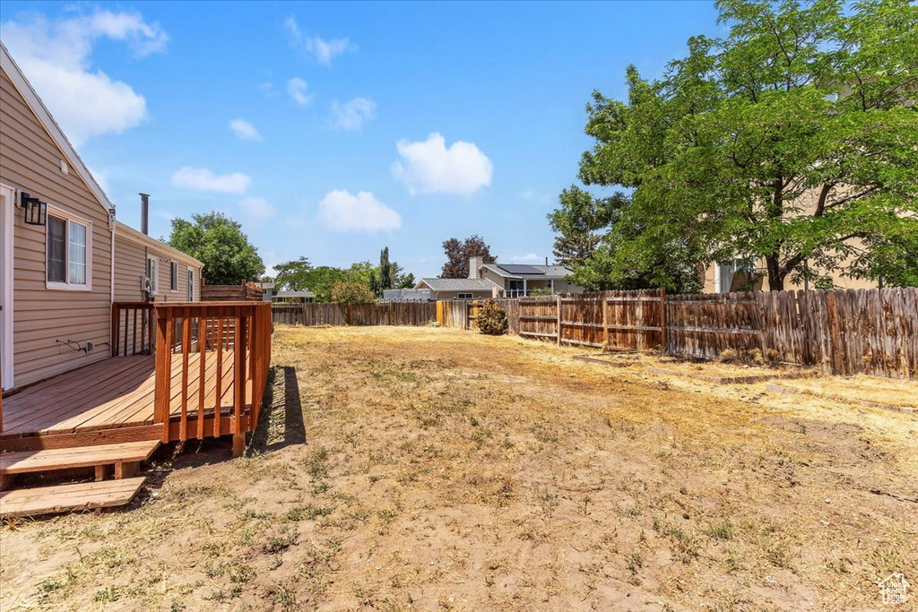 Fenced backyard featuring a deck