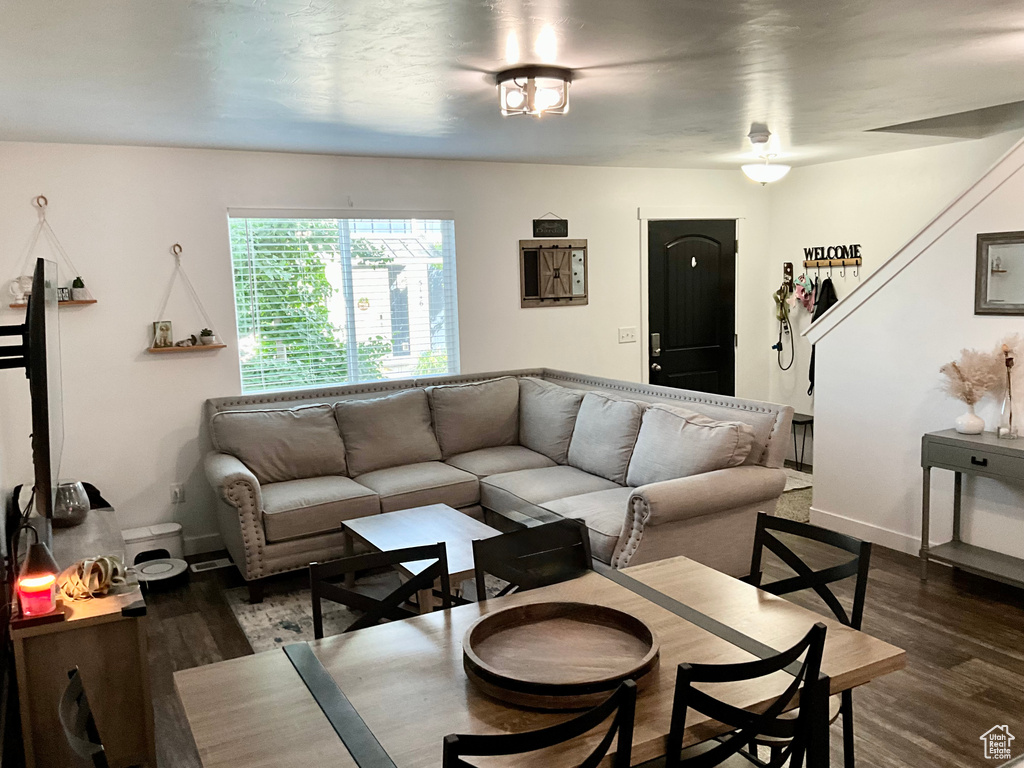 Living room with dark wood-type flooring and baseboards