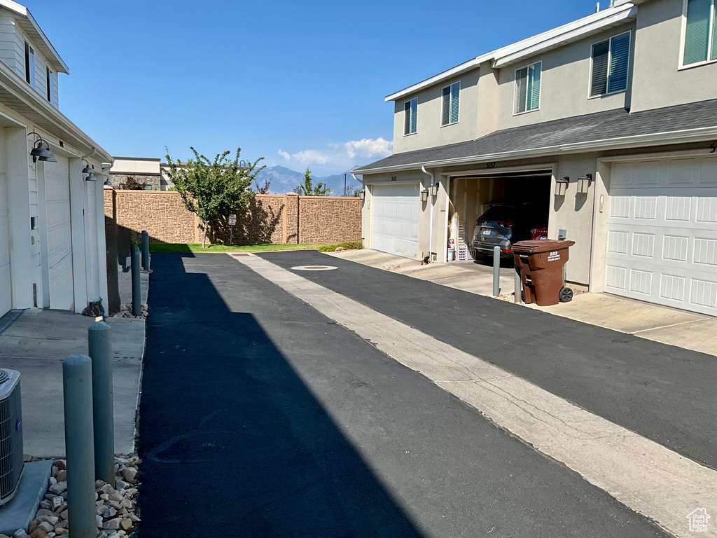 View of side of home featuring stucco siding, a garage, and a mountain view