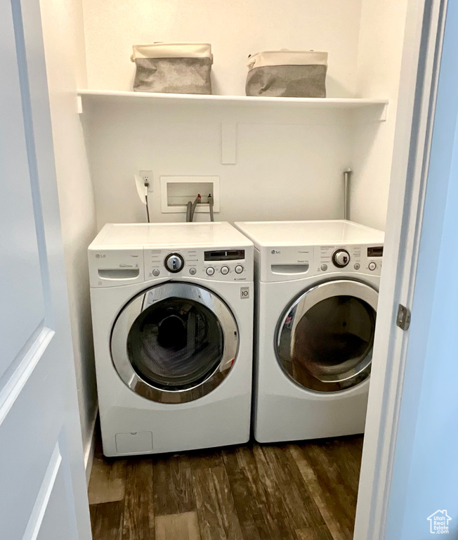 Laundry room featuring washer and dryer and dark wood finished floors