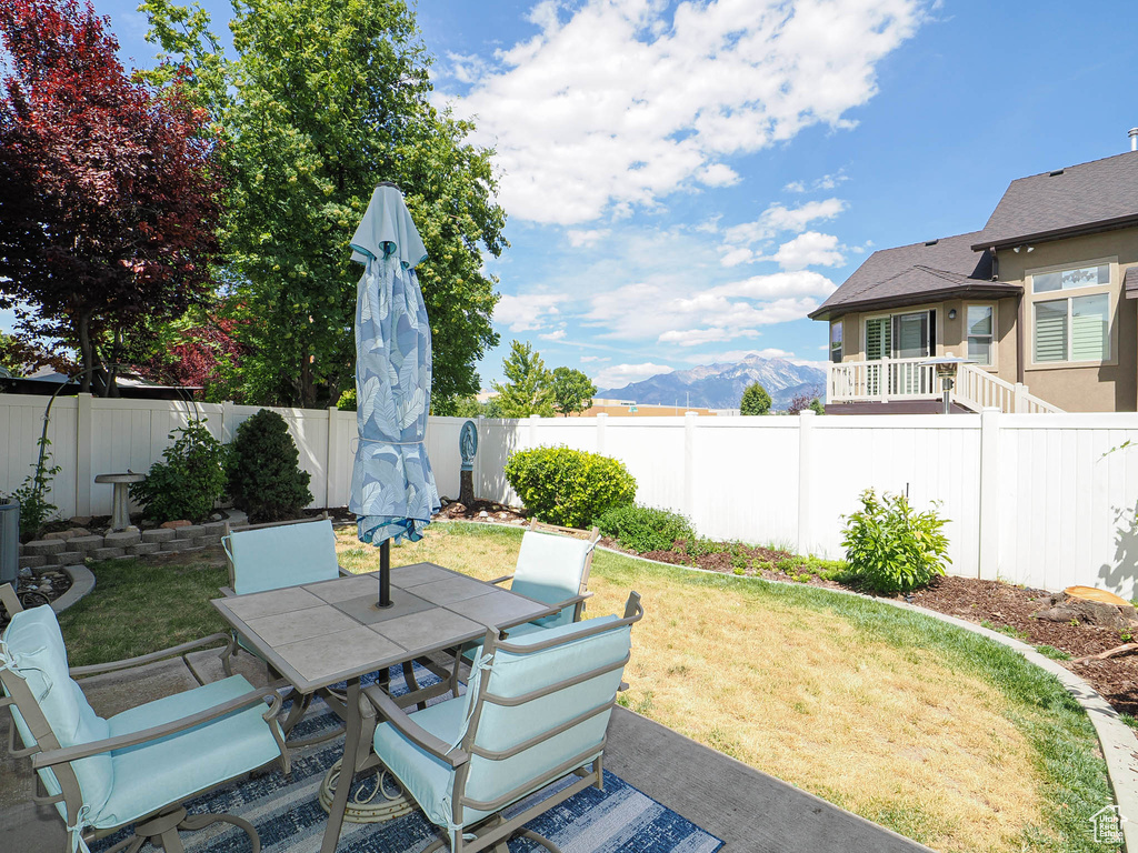 Fenced backyard featuring outdoor dining space and a mountain view