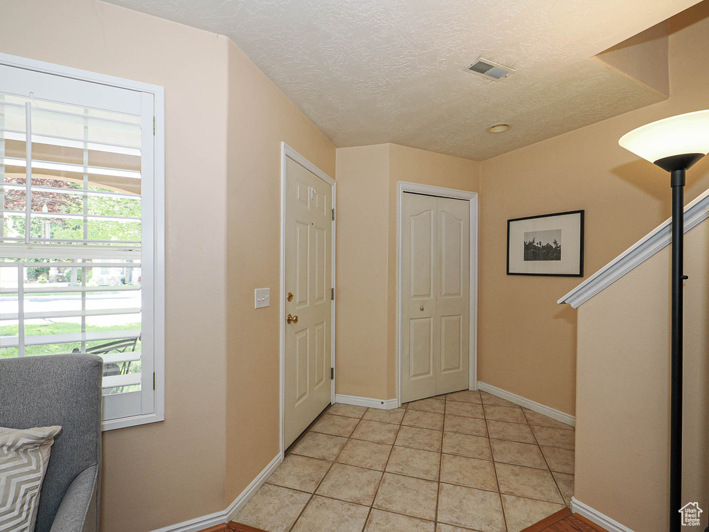Foyer entrance featuring baseboards and a textured ceiling
