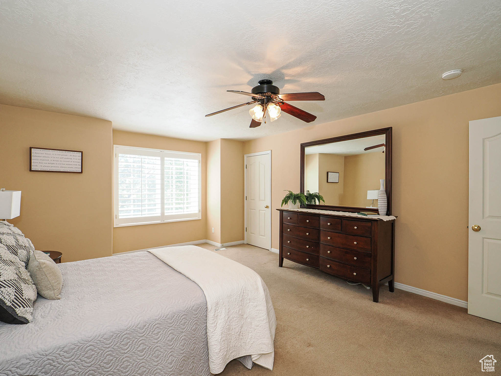 Bedroom with light colored carpet and ceiling fan