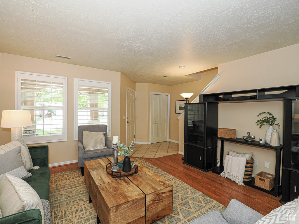 Living area with a textured ceiling and wood finished floors