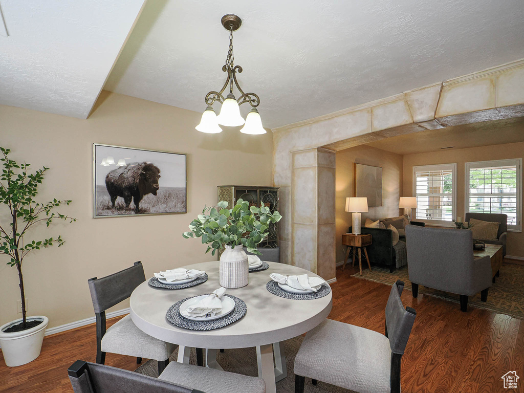 Dining space with wood finished floors and a chandelier