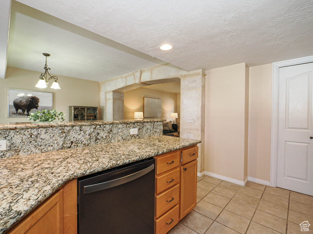 Kitchen featuring dishwasher, light tile patterned floors, open floor plan, light stone countertops, and brown cabinetry