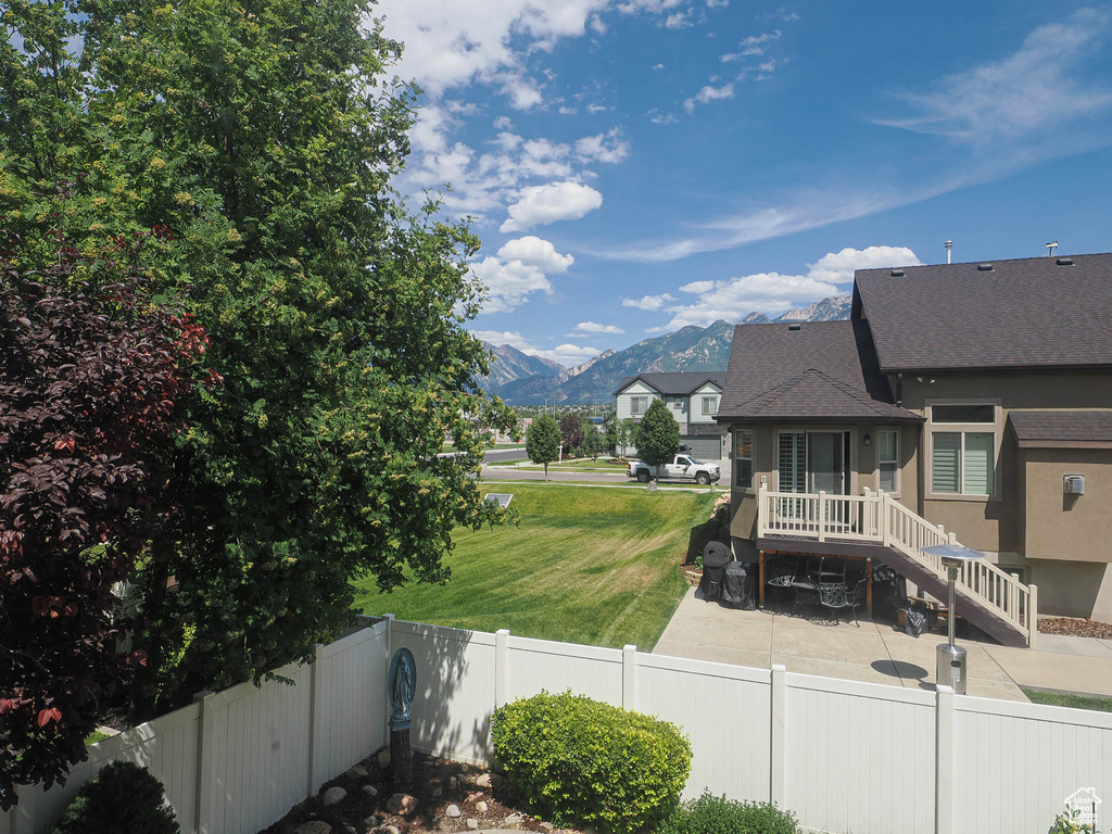 Fenced backyard featuring a mountain view and a patio area