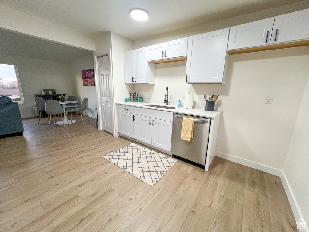 Kitchen featuring dishwasher, light wood-style flooring, white cabinetry, and light countertops