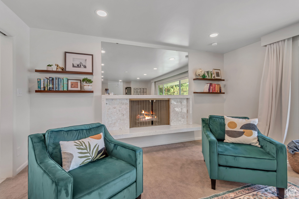 Living area featuring carpet floors, a lit fireplace, and recessed lighting
