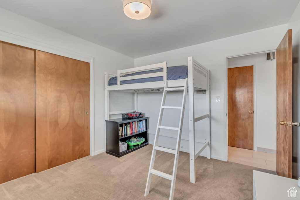 Carpeted bedroom featuring baseboards and a closet